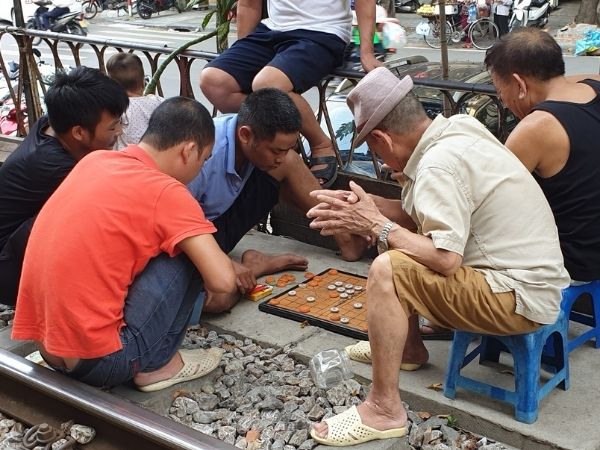 Men playing checkers on Train Street, Hanoi